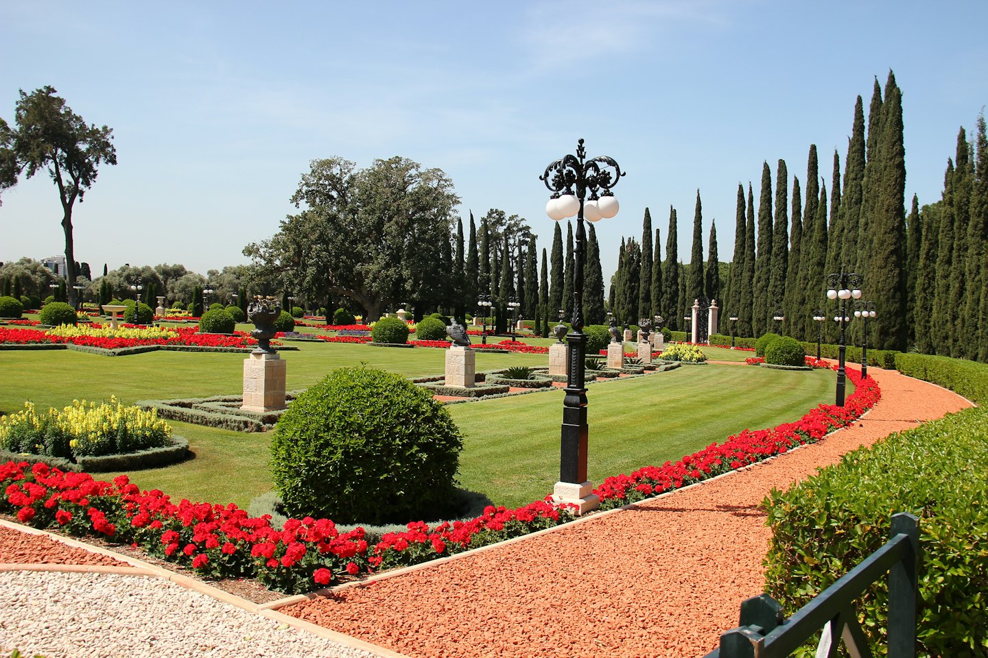 Un sentiero tortuoso di ghiaia attraversa un giardino ordinato con fiori.
